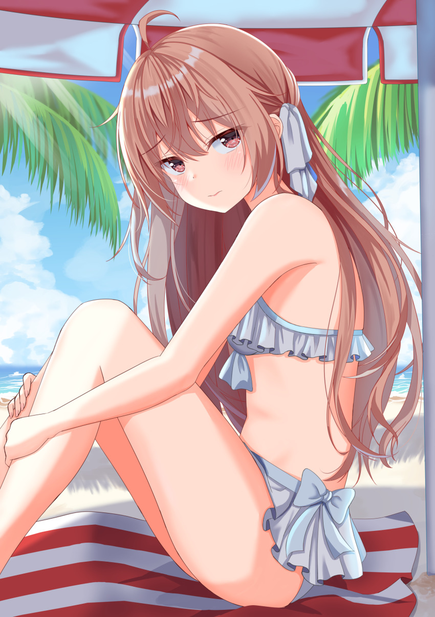 1girl absurdres ahoge bare_arms bare_legs bare_shoulders beach bikini bikini_skirt blue_bikini blue_bow blue_sky blush bow bow_bikini breasts brown_eyes brown_hair closed_mouth cloud day feet_out_of_frame frilled_bikini frills from_side furrowed_brow hair_between_eyes hair_ornament hands_on_own_legs highres knees_up light_rays long_hair looking_at_viewer looking_to_the_side natsumi_shiumi on_ground original outdoors palm_tree parasol sitting sky small_breasts solo striped_towel swimsuit tree umbrella