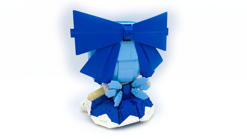 1girl blue_bow blue_dress blue_hair bow cirno commentary dress english_commentary facing_away fairy_wings from_behind full_body fumo_(doll) hair_bow highres lavishlump lego_(medium) light_blue_hair medium_hair short_sleeves simple_background sitting solo touhou unconventional_media white_background wings