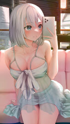  1girl absurdres alternate_breast_size blue_eyes bow breasts cellphone cleavage collarbone couch green_shirt green_skirt grey_hair highres indoors jakusha_shiro kaga_sumire large_breasts looking_at_phone phone see-through shirt short_hair sitting skirt smartphone smile solo taking_picture virtual_youtuber vspo! white_bow 