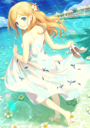  1girl bare_legs bare_shoulders barefoot beach blonde_hair blue_eyes blue_sky cloud cloudy_sky commentary_request day dress flower hair_flower hair_ornament high_heels highres holding long_hair looking_at_viewer looking_back ocean original outdoors shinonome_haru sky sleeveless sleeveless_dress smile solo standing sundress sunlight water white_dress 