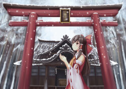  1girl absurdres ascot bow box brown_eyes brown_hair closed_mouth commentary detached_sleeves donation_box frilled_bow frilled_hair_tubes frills hair_bow hair_tubes hakurei_reimu hakurei_shrine highres long_hair outdoors piaoluo_de_ying_huaban red_bow red_skirt ribbon-trimmed_sleeves ribbon_trim skirt skirt_set smile snow snowing solo torii touhou yellow_ascot 