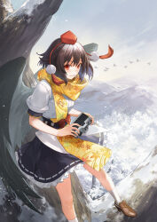1girl absurdres bare_tree bird bird_wings black_skirt black_wings blush brown_footwear brown_hair camera commentary feathered_wings foot_out_of_frame frilled_skirt frills hakou_(barasensou) hat highres holding holding_camera leaf_print looking_at_viewer mountainous_horizon parted_lips pom_pom_(clothes) puffy_short_sleeves puffy_sleeves red_eyes red_hat ribbon-trimmed_skirt ribbon_trim scarf shameimaru_aya shirt short_hair short_sleeves skirt smile snow socks solo tokin_hat touhou tree white_shirt white_socks wings yellow_scarf