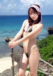  1girl asian beach bikini brown_hair cloud female_focus navel ocean outdoors photo_(medium) plant sky solo swimsuit  rating:Questionable score:15 user:ghstdrgn