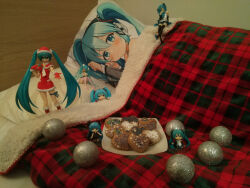  1girl 2d_dating bauble blue_hair christmas_ornaments cookie dakimakura_(object) figure food gift hat hatsune_miku heart highres long_hair photo_(medium) pillow plaid plate santa_costume santa_hat solo twintails under_covers very_long_hair vocaloid 