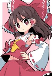  1girl :&lt; ascot azumi_haruhito border bow brown_hair detached_sleeves frilled_bow frilled_hair_tubes frills hair_tubes hakurei_reimu hands_on_own_hips highres midriff_peek navel pink_background red_bow red_eyes red_hair red_skirt ribbon_trim skirt skirt_set solo touhou v-shaped_eyebrows white_border wind yellow_ascot 