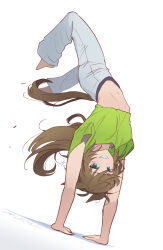  1girl alternate_costume arms_up artist_name barefoot brown_hair commentary crop_top green_eyes green_shirt grey_pants grin handstand highres long_hair looking_at_viewer midriff mr._c.b._(umamusume) mukakin navel pants shirt short_sleeves simple_background smile solo stomach tail umamusume upside-down white_background 
