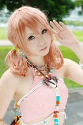 Rule 34 | 1girl, bracelet, cosplay, female focus, final fantasy, final fantasy xiii, grass, jewelry, looking at viewer, midriff, necklace, oerba dia vanille, oerba dia vanille (cosplay), outdoors, pink shirt, shirt, solo, tree, twintails