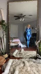 Rule 34 | 1girl, 60fps, animated, bedroom, blonde hair, bodysuit, breasts, cellphone, cosplay, highres, holding, holding phone, lowres, medium breasts, metroid, mirror image, nintendo, omgcosplay, phone, photo (medium), ponytail, real life, samus aran, samus aran (cosplay), shiny clothes, sitting, smartphone, smile, solo, sound, squatting, thighs, video, walking, zero suit