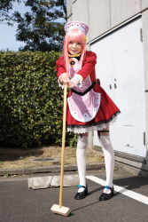Rule 34 | 1girl, apron, asian, black footwear, blurry, breasts, broom, cosplay, depth of field, dress, garter straps, hedge, highres, leaning forward, looking at viewer, maid, maid apron, makeup, mary janes, mascara, namada, nono (top wo nerae 2!), outdoors, parking lot, photo (medium), pigeon-toed, pink hair, puffy sleeves, shoes, short dress, sidelocks, small breasts, smile, solo, standing, thighhighs, top wo nerae 2!, tree, white thighhighs, zettai ryouiki