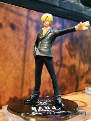 Rule 34 | 1boy, black footwear, black pants, blonde hair, cigarette, facial hair, figure, formal, goatee, grin, hair over one eye, hand in pocket, jolly roger, male focus, mustache, necktie, one piece, pants, photo (medium), pirate, sanji (one piece), shirt, shoes, smile, solo, suit, yellow shirt