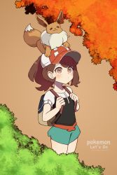 Rule 34 | 1girl, :3, artist name, backpack, bad id, bad pixiv id, bag, black shirt, blush, breasts, brown eyes, brown hair, copyright name, creatures (company), eevee, elaine (pokemon), english text, female focus, flat chest, floatingapple, game freak, gen 1 pokemon, green shorts, hands up, hat, highres, looking up, nintendo, on head, outdoors, poke ball theme, pokemon, pokemon (creature), pokemon lgpe, pokemon on head, ponytail, red hat, shirt, short shorts, short sleeves, shorts, smile, standing, tree, twitter username