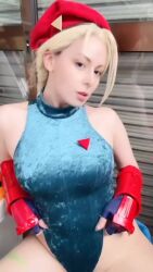 1girl animated armpits arms_up bare_shoulders blonde_hair breasts cammy_white cammy_white_(cosplay) cosplay fingerless_gloves gloves hat highleg highleg_leotard large_breasts leotard long_hair real_life sitting sleeveless street_fighter tagme video yuriko_tiger