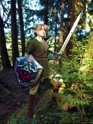 Rule 34 | armor, belt, blonde hair, blue eyes, boots, chainmail, cosplay, forest, hat, likovacs, link, nature, nintendo, outdoors, photo (medium), pointy ears, shield, solo, standing, sword, the legend of zelda, the legend of zelda: twilight princess, tree, weapon