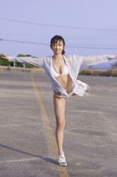 Rule 34 | 1girl, bikini, blurry, blurry background, highres, komiya arisa, looking at viewer, one leg raised, open clothes, open shirt, outdoors, outstretched arms, photo (medium), shoes, sneakers, standing, swimsuit, voice actor, white bikini