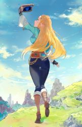 Rule 34 | 1girl, aisutabetao, arm up, ass, bag, black gloves, blonde hair, blue pants, blue shirt, blue sky, boots, braid, breasts, brown bag, brown footwear, cloud, crown braid, day, fingerless gloves, floating hair, from behind, full body, gloves, green eyes, hair ornament, hairclip, highres, holding, large breasts, long hair, looking away, mountain, nintendo, outdoors, pants, pointy ears, princess zelda, satchel, sheikah slate, shirt, sky, solo, the legend of zelda, the legend of zelda: breath of the wild