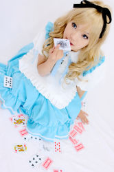 Rule 34 | 1girl, ace (playing card), alice (alice in wonderland), alice (alice in wonderland) (cosplay), alice in wonderland, asian, blue eyes, breasts, card, color contacts, cosplay, dutch angle, indoors, kipi-san, long hair, mole, petite, photo (medium), playing card, simple background, small breasts, solo, white background