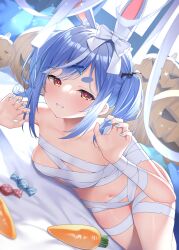 1girl absurdres animal_ears bandaged_arm bandaged_chest bandaged_ear bandaged_leg bandaged_wrist bandages blue_hair blue_nails blush breasts candy carrot commentary_request food grin halloween halloween_costume highres hololive looking_at_viewer lying mummy_costume nail_polish naked_bandage navel on_side pumpkin rabbit_ears shimo_(shimo332215) small_breasts smile solo thick_eyebrows usada_pekora virtual_youtuber