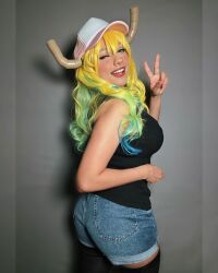 Rule 34 | 1girl, ass, bare shoulders, black thighhighs, blonde hair, blue hair, breasts, cosplay, dragon horns, female focus, green eyes, green hair, grey background, highres, horns, kobayashi-san chi no maidragon, large breasts, looking at viewer, lucoa (maidragon), mexican (nationality), multicolored hair, one eye closed, photo (medium), short shorts, shorts, smile, solo, taliverse, teeth, thighhighs, thighs, v
