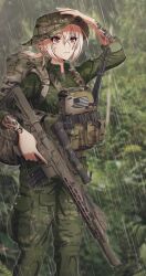 Rule 34 | 1girl, arm up, assault rifle, backpack, bag, blurry, blurry background, camouflage, camouflage headwear, camouflage jacket, camouflage pants, dausagi, depth of field, feet out of frame, green headwear, green jacket, green pants, gun, h&amp;k hk416, hand on headwear, highres, holding, holding gun, holding weapon, jacket, long sleeves, original, outdoors, pants, rain, rifle, scope, solo, standing, trigger discipline, weapon