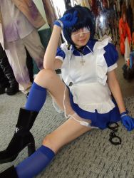 Rule 34 | 1girl, apron, asian, black footwear, blue eyes, blue gloves, blue hair, blue socks, boots, collar, color contacts, cosplay, cross, cuffs, dutch angle, eyepatch, gloves, handcuffs, high heels, ikkitousen, indoors, kneehighs, looking at viewer, maid, maid apron, namada, on floor, photo (medium), puffy short sleeves, puffy sleeves, reflection, ryomou shimei, ryomou shimei (cosplay), short sleeves, sitting, socks, solo focus
