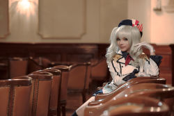 Rule 34 | 1girl, beret, black socks, blue hat, blue skirt, blurry, brown eyes, chair, closed mouth, commentary, cosplay, cosplay photo, depth of field, epaulettes, gloves, hand in own hair, hat, indoors, jacket, kantai collection, kashima (kancolle), kerchief, kneehighs, lips, long hair, long sleeves, looking at viewer, may sakaali, military jacket, miniskirt, nose, on chair, photo (medium), pleated skirt, red kerchief, silver hair, sitting, skirt, socks, solo, twintails, wavy hair, white gloves