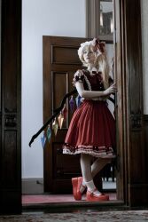 Rule 34 | 1girl, absurdres, blonde hair, cosplay photo, crystal, flandre scarlet, full body, hat, highres, indoors, mary janes, medium hair, medium skirt, minimum box, mob cap, multicolored wings, one side up, open door, photo (medium), red footwear, red skirt, red vest, rug, shoes, skirt, socks, solo, standing, touhou, vest, white hat, white skirt, white socks, wings, wooden door