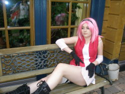 Rule 34 | 1girl, arm warmers, bandages, bare shoulders, black footwear, black gloves, boots, breasts, cosplay, dress, female focus, gloves, green eyes, haruno sakura, headband, highres, large breasts, legs, long hair, looking to the side, miniskirt, naruto, naruto (series), photo (medium), pink hair, red shirt, reflection, shirt, short hair, skirt, sleeveless, sleeveless shirt, solo, strap slip, thigh strap, thighs, white skirt