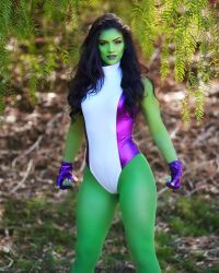 Rule 34 | 1girl, breasts, bush, colored skin, cosplay, day, feet out of frame, fingerless gloves, gloves, grass, green hair, green skin, highres, leotard, lips, looking at viewer, marvel, medium breasts, nature, photo (medium), purple leotard, she-hulk, she-hulk (cosplay), simple background, skin tight, smile, standing, thighs, two-tone leotard, wide hips, zoogirlq