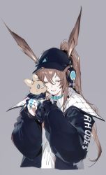 Rule 34 | 1girl, amiya (arknights), amiya (newsgirl) (arknights), animal ears, arknights, black hat, black jacket, brown hair, chuzenji, closed eyes, clothes writing, cropped torso, grey background, hair between eyes, hat, headphones, highres, holding, holding stuffed toy, hood, hood down, hooded jacket, jacket, jewelry, long hair, long sleeves, multiple rings, neck ring, official alternate costume, open clothes, open jacket, open mouth, ponytail, rabbit ears, ring, sidelocks, simple background, solo, stuffed animal, stuffed toy, thumb ring