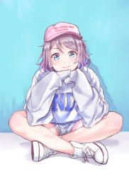 Rule 34 | 1girl, baseball cap, blue background, blue eyes, clothes writing, grey hair, hat, headwear writing, high tops, highres, indian style, kanabun, long sleeves, looking at viewer, love live!, love live! sunshine!!, own hands together, pink hat, shoes, short hair, shorts, sitting, sleeves past wrists, smile, sneakers, solo, sweater, watanabe you, white footwear