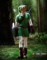 Rule 34 | 1boy, belt, blonde hair, boots, cosplay, forest, full body, hat, link, male focus, nature, nintendo, outdoors, photo (medium), plant, pointy ears, shield, solo, sword, the legend of zelda, tunic, weapon, wings