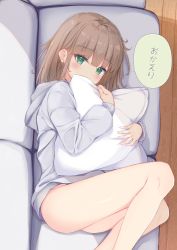 Rule 34 | 1girl, blush, brown hair, commentary request, couch, covered mouth, feet out of frame, green eyes, grey hoodie, highres, hood, hood down, hoodie, indoors, long hair, long sleeves, looking at viewer, lying, hugging object, on couch, on side, original, pillow, pillow hug, sashima, solo, translation request, wooden floor