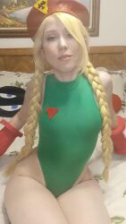 Rule 34 | 1girl, bed, blonde hair, braid, breasts, cammy white, cammy white (cosplay), capcom, cosplay, curvy, green leotard, hat, highleg, highleg leotard, highres, ikuy, legs together, leotard, long hair, looking at viewer, on bed, photo (medium), sitting, small breasts, street fighter, thong leotard, twin braids, very long hair