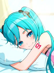 1girl aqua_eyes aqua_hair black_bow blush bow character_name closed_mouth commentary hair_bow hatsune_miku highres long_hair looking_at_viewer lying morning number_tattoo pajamas pillow ribon_(shueisha) shoulder_tattoo smile solo tattoo uzuki_sena vocaloid waking_up