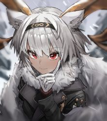 1girl, animal ears, arknights, bangs, black coat, blurry, blurry background, carnelian (arknights), carnelian (hohenlohe chillysand) (arknights), closed mouth, coat, collarbone, dark-skinned female, dark skin, depth of field, eyebrows visible through hair, fur collar, gloves, goat ears, goat girl, goat horns, hand on own cheek, hand on own face, highres, horns, long sleeves, looking at viewer, official alternate costume, outdoors, raw egg lent, red eyes, short hair, silver hair, smile, snowing, solo, upper body, white gloves