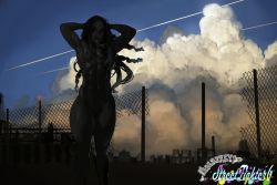 Rule 34 | 1girl, abs, adjusting hair, alternate hairstyle, alternate muscle size, arms behind head, arms up, black hair, capcom, chain-link fence, cityscape, cloud, cloudy sky, dark-skinned female, dark skin, feet out of frame, fence, green hair, hair down, kimberly jackson, multicolored hair, muscular, muscular female, nude, outdoors, sky, solo, standing, street fighter, street fighter 6, thick thighs, thighs, very dark skin, watermark, ziromaru