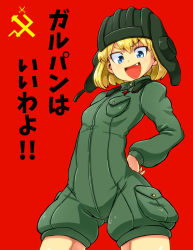 Rule 34 | 10s, 1girl, aono3, arm behind back, blonde hair, blue eyes, cowboy shot, emblem, fang, girls und panzer, green jumpsuit, hand on own hip, helmet, highres, jumpsuit, katyusha (girls und panzer), long sleeves, looking at viewer, military, military uniform, open mouth, pravda (emblem), pravda military uniform, red background, short hair, short jumpsuit, simple background, smile, solo, tank helmet, uniform