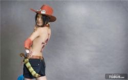 Rule 34 | 1girl, back tattoo, bag, belt, black hair, breasts, cosplay, dagger, facing viewer, female focus, genderswap, genderswap (mtf), hand on own hip, hand up, happy, hat, hat ornament, jewelry, knife, looking at viewer, looking back, lowres, necklace, one piece, photo (medium), portgas d. ace, portgas d. ace (cosplay), portgas d. anne, portgas d. anne (cosplay), scabbard, sheath, sheathed, short hair, shorts, smile, solo, standing, tattoo, thigh strap, topless, upper body, weapon
