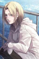 Rule 34 | 1girl, annie leonhart, askgcom, blonde hair, blue eyes, closed mouth, coat, expressionless, feet out of frame, highres, hood, hood down, hooded coat, long sleeves, looking at viewer, medium hair, ocean, outdoors, parted bangs, shingeki no kyojin, solo, squatting, white coat