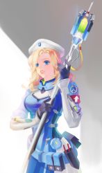 Rule 34 | 1girl, alternate hairstyle, armband, belt, beret, black gloves, blonde hair, blue bodysuit, blue eyes, bodysuit, boya (user cdjw4444), breasts, combat medic ziegler, commentary request, cowboy shot, emblem, eyes visible through hair, glint, gloves, grey background, hair over one eye, hat, highres, holding, holding staff, logo, long sleeves, looking at viewer, mechanical wings, medium breasts, mercy (overwatch), no wings, official alternate costume, overwatch, overwatch 1, parted lips, pelvic curtain, pink lips, pliers, solo, staff, utility belt, white background, white hat, wings