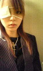 Rule 34 | 1girl, brown hair, eyepatch, formal, hirano aya, indoors, jewelry, long hair, looking at viewer, lowres, necklace, photo (medium), real life, voice actor, serious, solo, suit