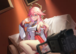 Rule 34 | 1girl, bare legs, bare shoulders, blush, breasts, couch, genshin impact, hair between eyes, hair ornament, half-closed eyes, highres, indoors, japanese clothes, large breasts, legs, long hair, long sleeves, looking at viewer, miko, on couch, parted lips, pink hair, sideboob, sitting, solo, video camera, wide sleeves, yae miko, yin lan xue