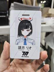 Rule 34 | 1girl, 1other, alternate costume, alternate hairstyle, black hair, blue archive, highres, id card, japanese text, looking at viewer, photo (medium), raki kr, red eyes, rio (blue archive), shirt, short hair, twitter, white shirt