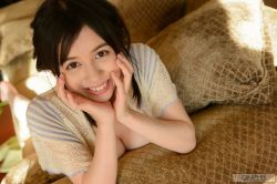 Rule 34 | 1girl, blurry, blurry background, breasts, brown eyes, brown hair, female focus, hands on own face, happy, highres, japanese (nationality), large breasts, looking at viewer, lying, medium hair, on bed, on stomach, photo (medium), smile, solo, tagme, teeth, yoshikawa aimi
