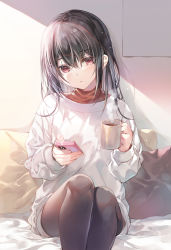 Rule 34 | 1girl, baggy clothes, black hair, blush, bottomless, cellphone, coffee mug, commentary request, cup, hair between eyes, hair ornament, hairclip, highres, holding, holding cup, holding phone, long hair, looking at viewer, miwabe sakura, mug, on bed, orange shirt, original, pantyhose, phone, pillow, red eyes, shirt, sitting, steam, sweater