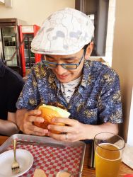 Rule 34 | 2boys, alcohol, bad id, bad twitter id, beer, black hair, blue-framed eyewear, coca-cola, drink, flat cap, food, fork, glass, glasses, burger, hat, highres, holding, holding food, jewelry, knife, looking down, multiple boys, photo (medium), real life, restaurant, ring, short hair, short sleeves, smile, table, touhou, tray, wedding band, zun, zun hat
