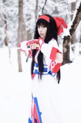 Rule 34 | 1girl, ainu clothes, black eyes, black hair, breasts, cosplay, fighting stance, fingerless gloves, gloves, hair ribbon, highres, long hair, looking at viewer, nakoruru, photo (medium), real life, ribbon, samurai spirits, small breasts, snk, snow, solo, the king of fighters