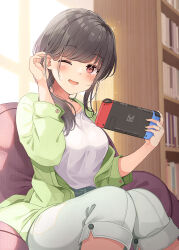 Rule 34 | 1girl, ;d, black hair, book, bookshelf, breasts, commentary request, green jacket, tucking hair, hands up, holding, indoors, jacket, knees together feet apart, long hair, long sleeves, looking at viewer, medium breasts, niichi (komorebi-palette), nintendo switch, one eye closed, open clothes, open jacket, open mouth, original, pants, puffy long sleeves, puffy sleeves, red eyes, shirt, sitting, smile, solo, white pants, white shirt