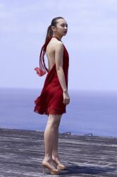 Rule 34 | 1girl, backless outfit, blurry, blurry background, dress, highres, komiya arisa, looking away, ocean, open clothes, outdoors, photo (medium), ponytail, red dress, standing, voice actor