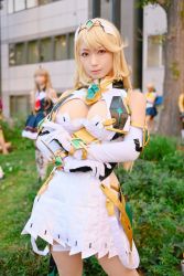 Rule 34 | 1girl, bare shoulders, blonde hair, breasts, brown eyes, cleavage, cosplay, cosplay photo, crossed arms, detached sleeves, dress, elbow gloves, gem, gloves, headpiece, jewelry, long hair, mythra (xenoblade), nintendo, photo (medium), real life, solo, swept bangs, tiara, white dress, white gloves, xenoblade chronicles (series), xenoblade chronicles 2